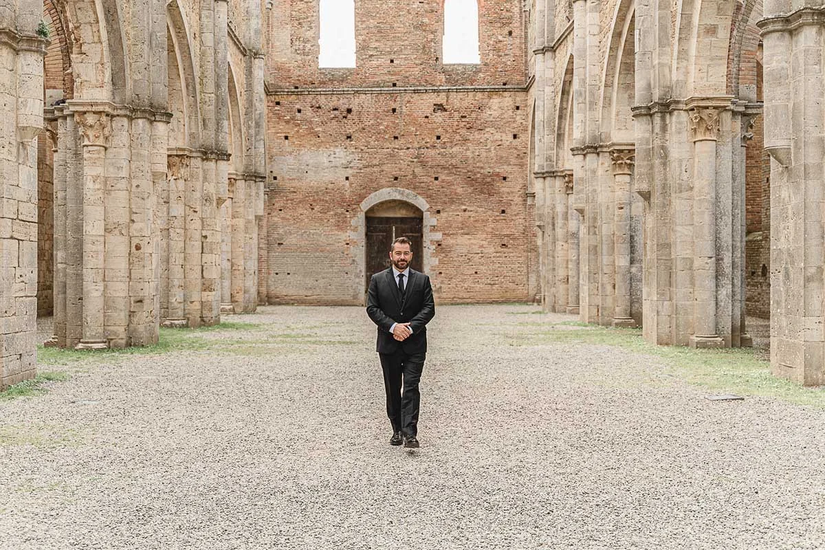elopment wedding in Tuscany-San Galgano-04 Groom standing alone at the altar of San Galgano Abbey waiting for his bride