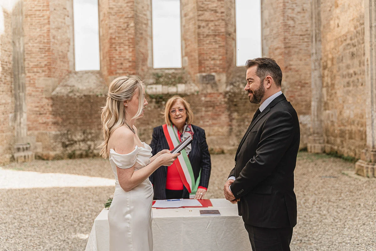 elopment wedding in Tuscany-San Galgano-18 Officiant reading the ceremony at San Galgano Abbey with bride and groom
