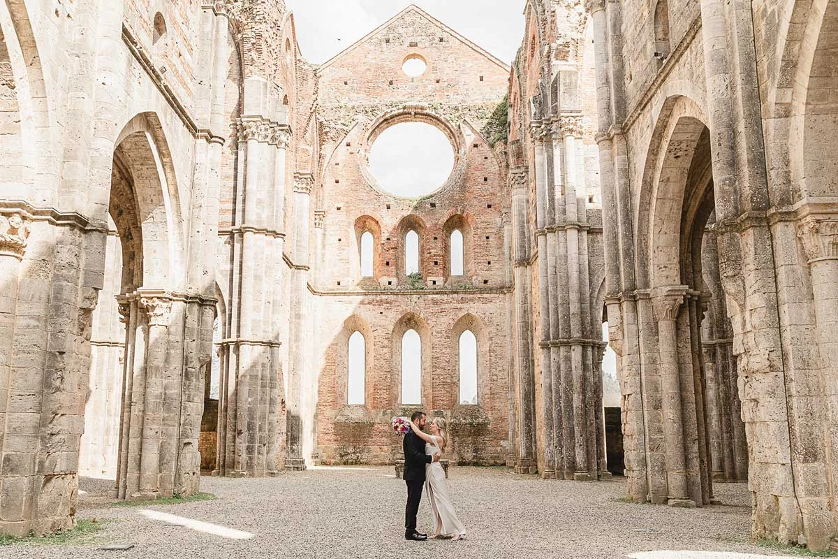 elopment wedding in Tuscany-San Galgano-30 Wide shot of couple alone inside the roofless nave of San Galgano Abbey