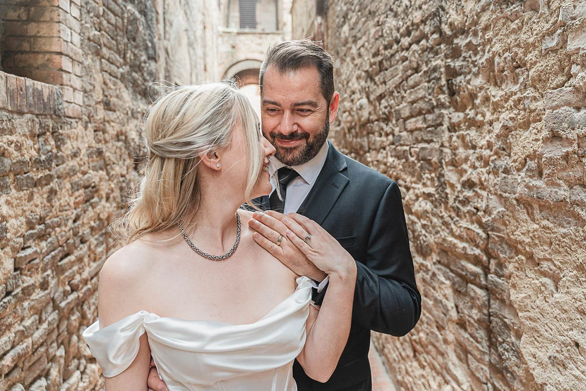 elopment wedding in Tuscany-San Galgano-47 Couple sharing an intimate moment against the ancient stone walls of San Galgano Abbey