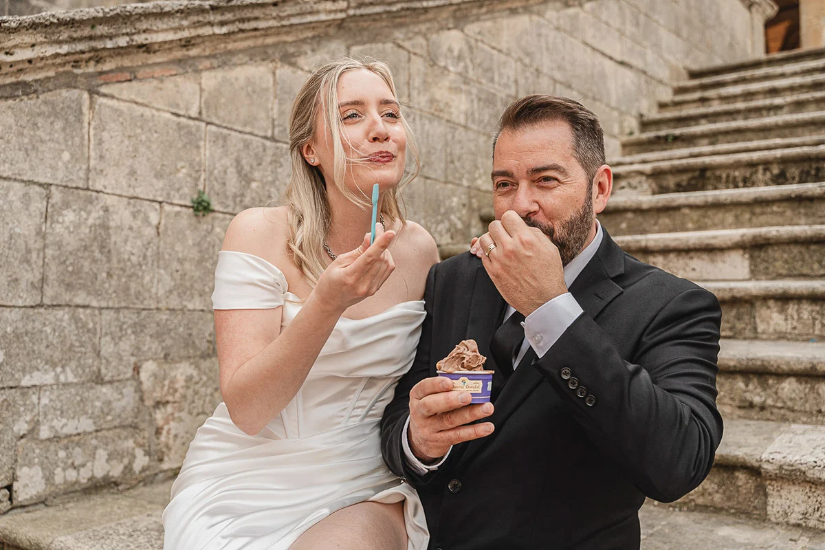 elopment wedding in Tuscany-San Galgano-49 Bride and groom eating gelato on the steps of San Galgano Abbey after their elopement