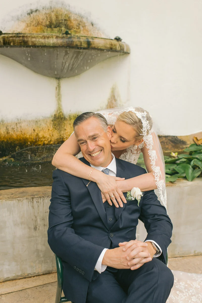 Jennifer hugging Ethan from behind, laughing couple portrait at Biester Palace